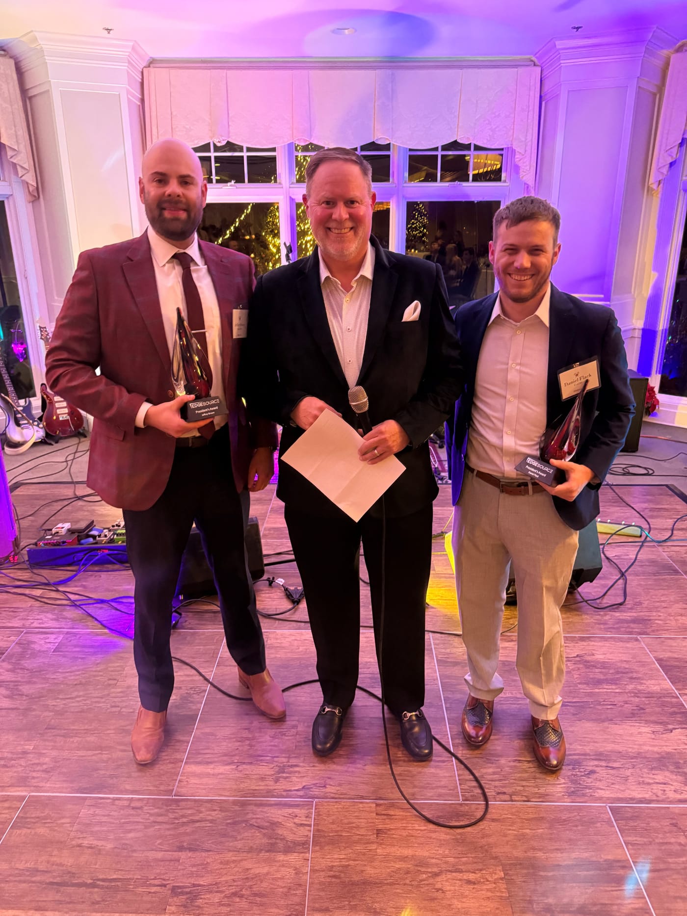 Edgesource team members holding President's Award trophies at the holiday party